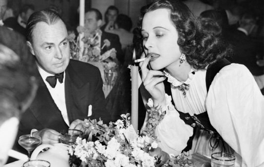 SZT2999340 Gene Markey and Hedy Lamarr, 1939 (b/w photo); (add.info.: Los Angeles, California, United States of America
Hedy Lamarr with her husband, the writer Gene Markey, on a party in Hollywood, given by Basil Rathbone and his wife. The actress lights a cigarette on a candle.
Gene Markey und Hedy Lamarr, 1939); © SZ Photo / Scherl; PERMISSION REQUIRED FOR NON EDITORIAL USAGE;  out of copyright

PLEASE NOTE: Bridgeman Images works with the owner of this image to clear permission. If you wish to reproduce this image, please inform us so we can clear permission for you.